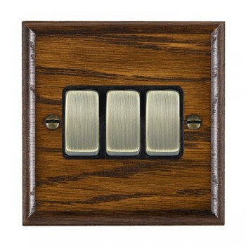 Hamilton Woods Ovolo Dark Oak 3 Gang 10AX 2 Way Switch with Antique Brass Rockers and Black Surround