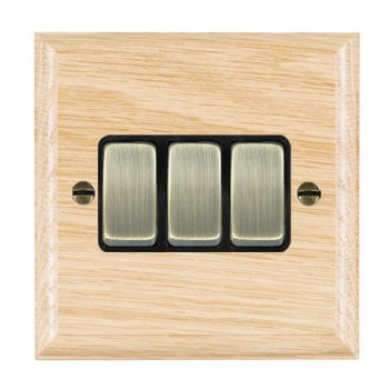 Hamilton Woods Ovolo Light Oak 3 Gang 10AX 2 Way Switch with Antique Brass Rockers and Black Surround